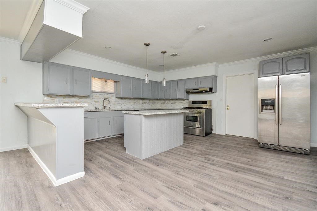 917 Defender Street Houston, TX 77029 - Photo 7 of 14 a kitchen with stainless steel appliances granite countertop a stove top oven a sink and white cabinets