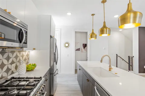 a kitchen with stainless steel appliances a stove a sink and a refrigerator