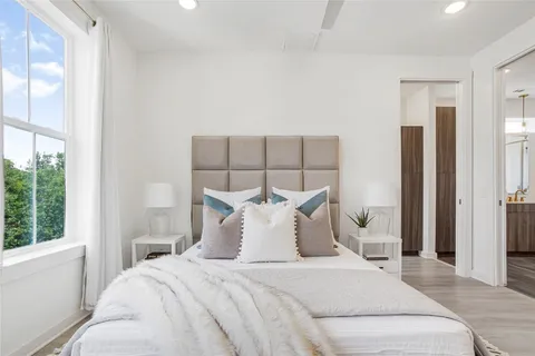 a bedroom with a bed and a large window