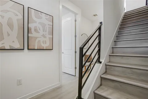 a view of staircase with wooden floor and white walls