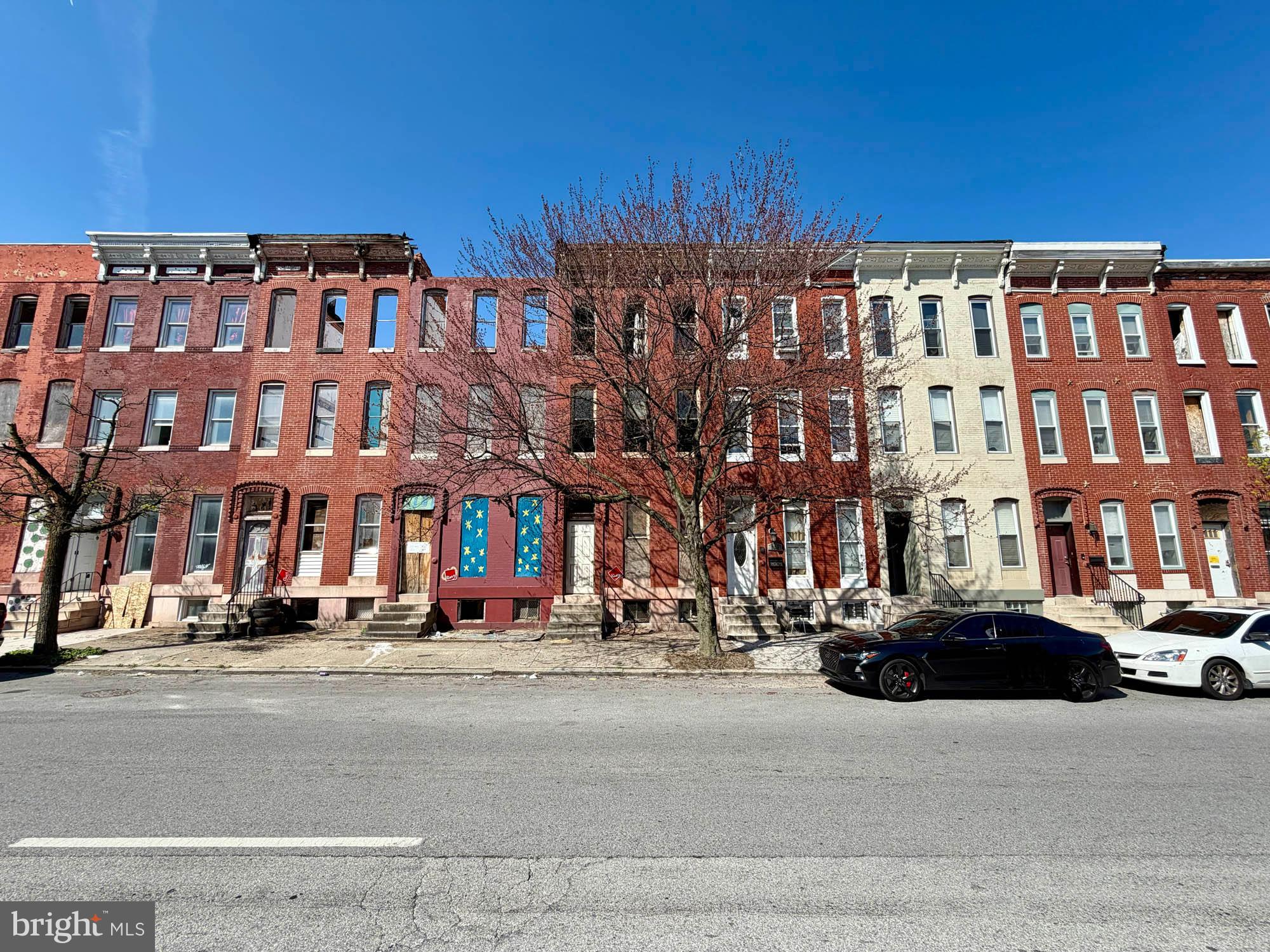 736 North Fulton Avenue Baltimore, MD 21217 - Photo 2 of 2 a front view of a building with lot of cars and trees