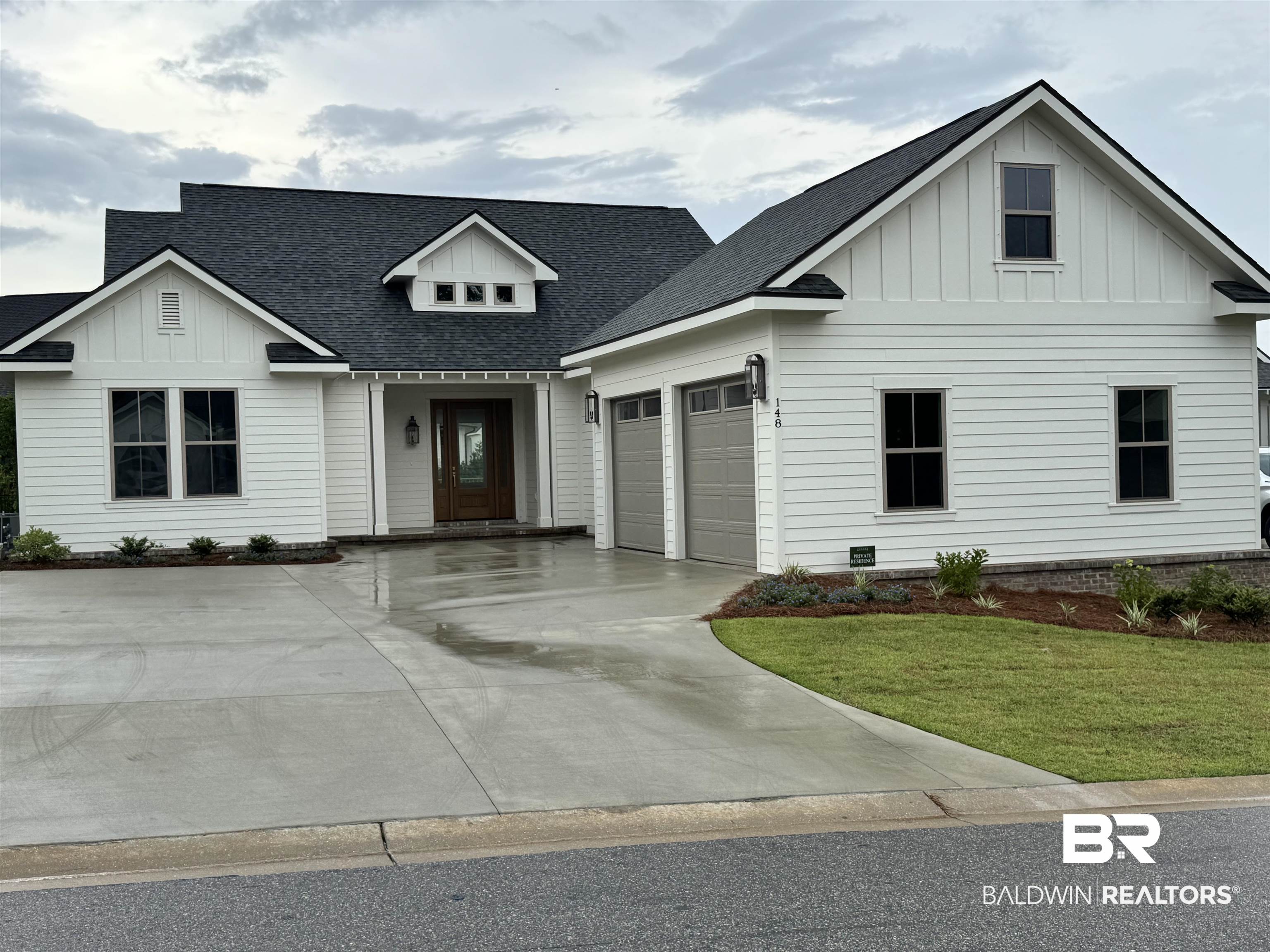 148 Hyacinth Street Fairhope, AL 36532 - Photo 1 of 2 Modern farmhouse style home featuring board and batten siding, a garage, concrete driveway, a front yard, and a shingled roof