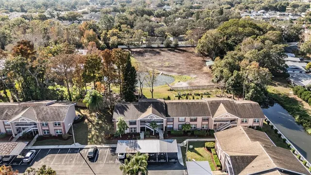 an aerial view of a house with a yard and lake view in back
