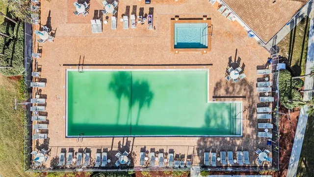 a view of swimming pool and chairs in patio