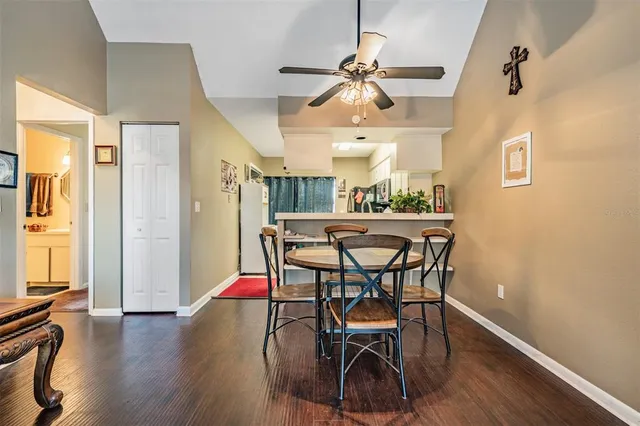 a dining room with furniture and a chandelier fan