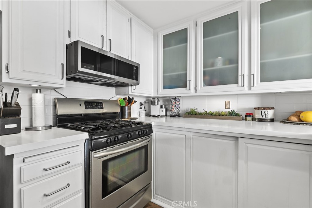 255 Main Street, Unit 103 Venice, CA 90291 - Photo 10 of 37 a kitchen with stainless steel appliances granite countertop white cabinets and black stove top oven with granite countertops