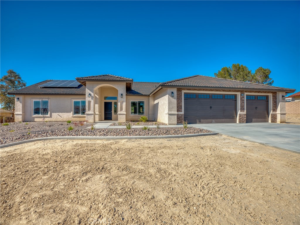 16358 Kamana Road Apple Valley, CA 92307 - Photo 1 of 1 a front view of a house with a garden