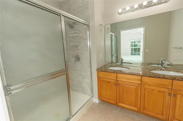 a bathroom with a granite countertop sink a mirror and a shower