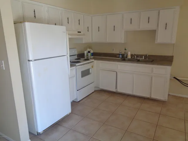 a white refrigerator freezer sitting inside of a kitchen