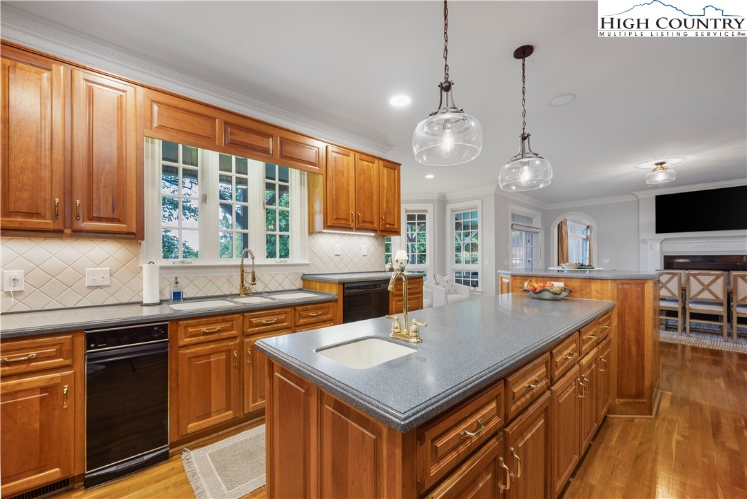 738 Country Club Road Glade Valley, NC 28627 - Photo 19 of 45 a kitchen with a stove a sink dishwasher a kitchen island with wooden cabinets and floor