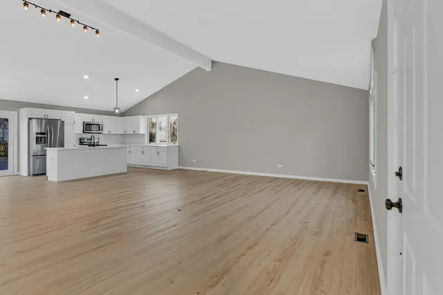 a view of a house with a barbeque and wooden stairs