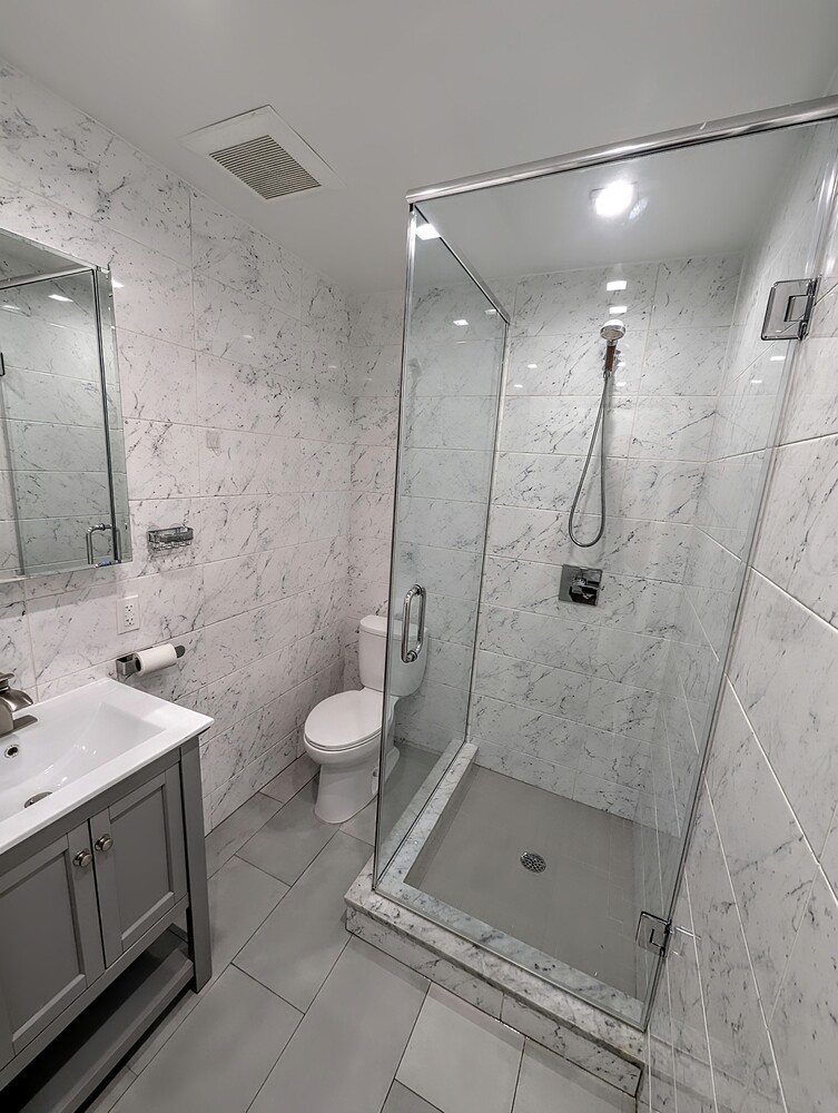 1661 Nostrand Avenue, Unit 2F Brooklyn, NY 11226 - Photo 5 of 8 a bathroom with a shower sink mirror and toilet
