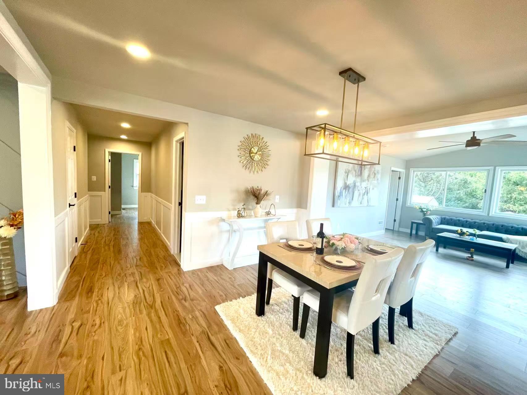 1212 Random Ridge Road Westminster, MD 21157 - Photo 9 of 36 a dining room with wooden floor a chandelier a wooden table and chairs