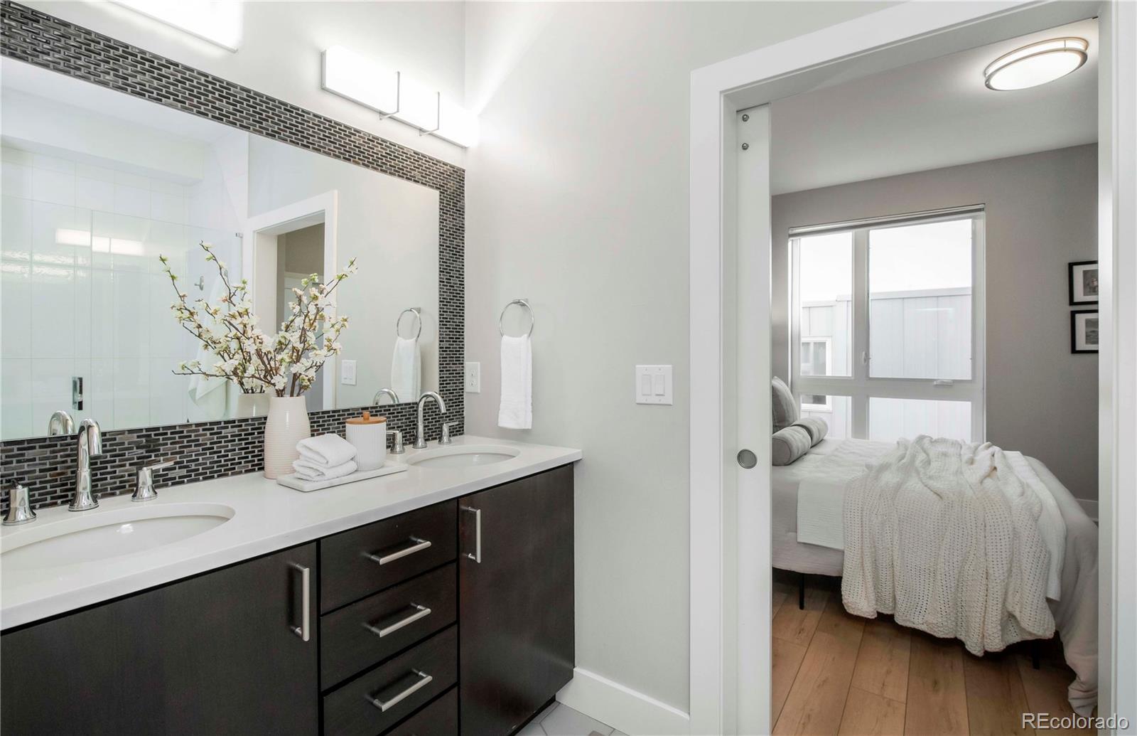 1933 Grove Street Denver, CO 80204 - Photo 18 of 29 a en suite bathroom with a double vanity sink and a mirror