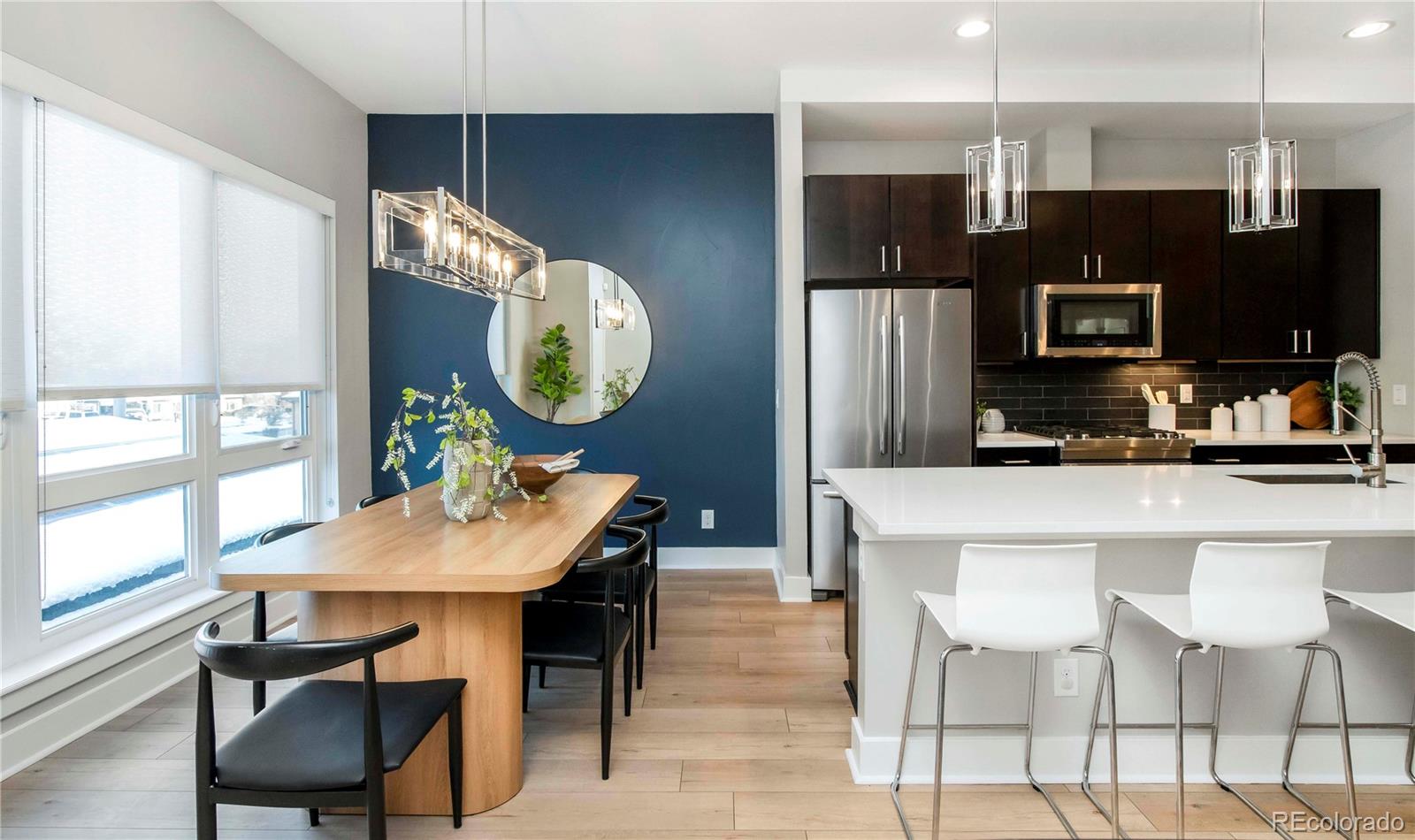 1933 Grove Street Denver, CO 80204 - Photo 10 of 29 a kitchen with stainless steel appliances a table chairs and a refrigerator