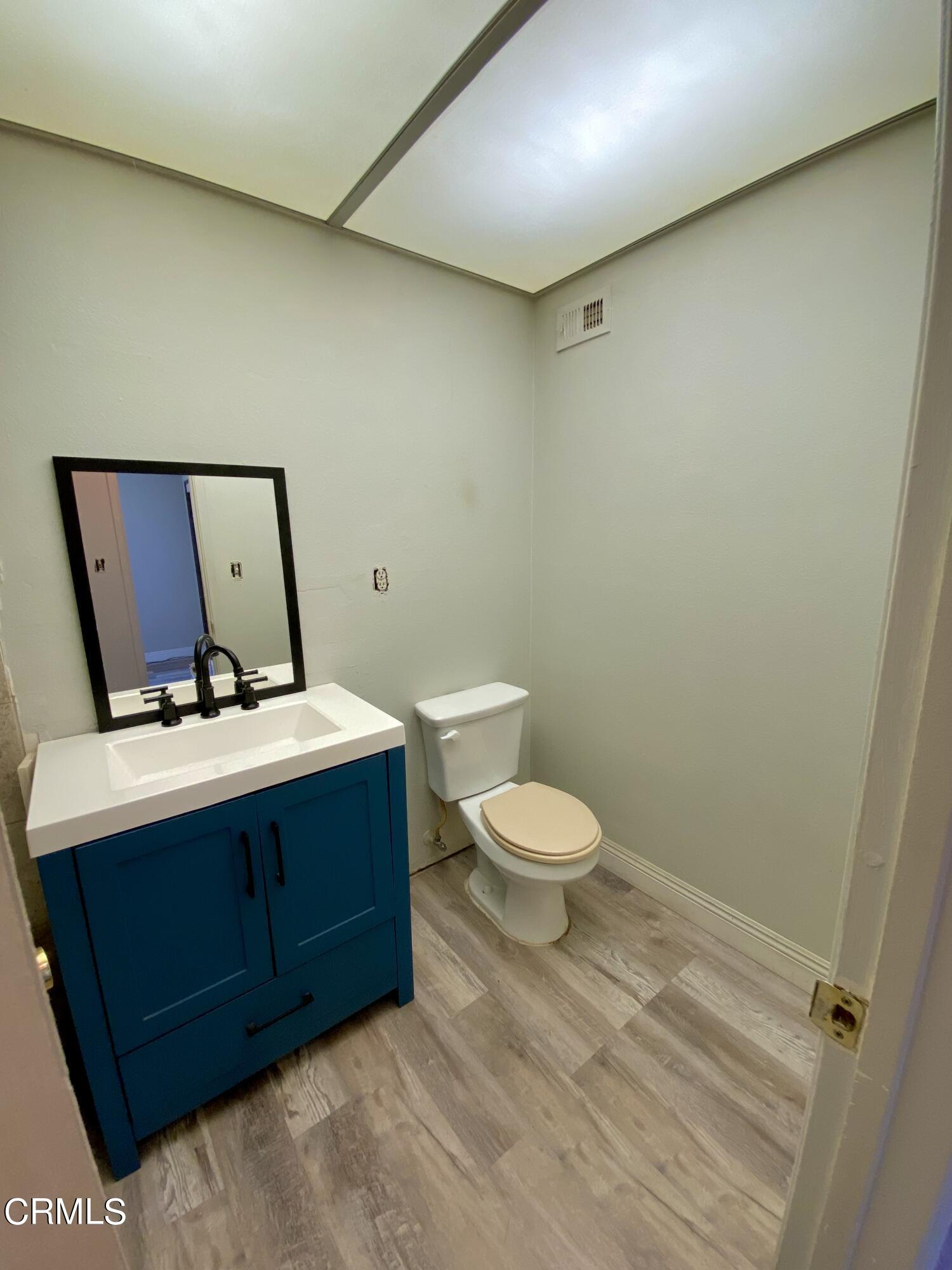 930 West Olive Street Oxnard, CA 93033 - Photo 13 of 22 a bathroom with a toilet a sink and mirror