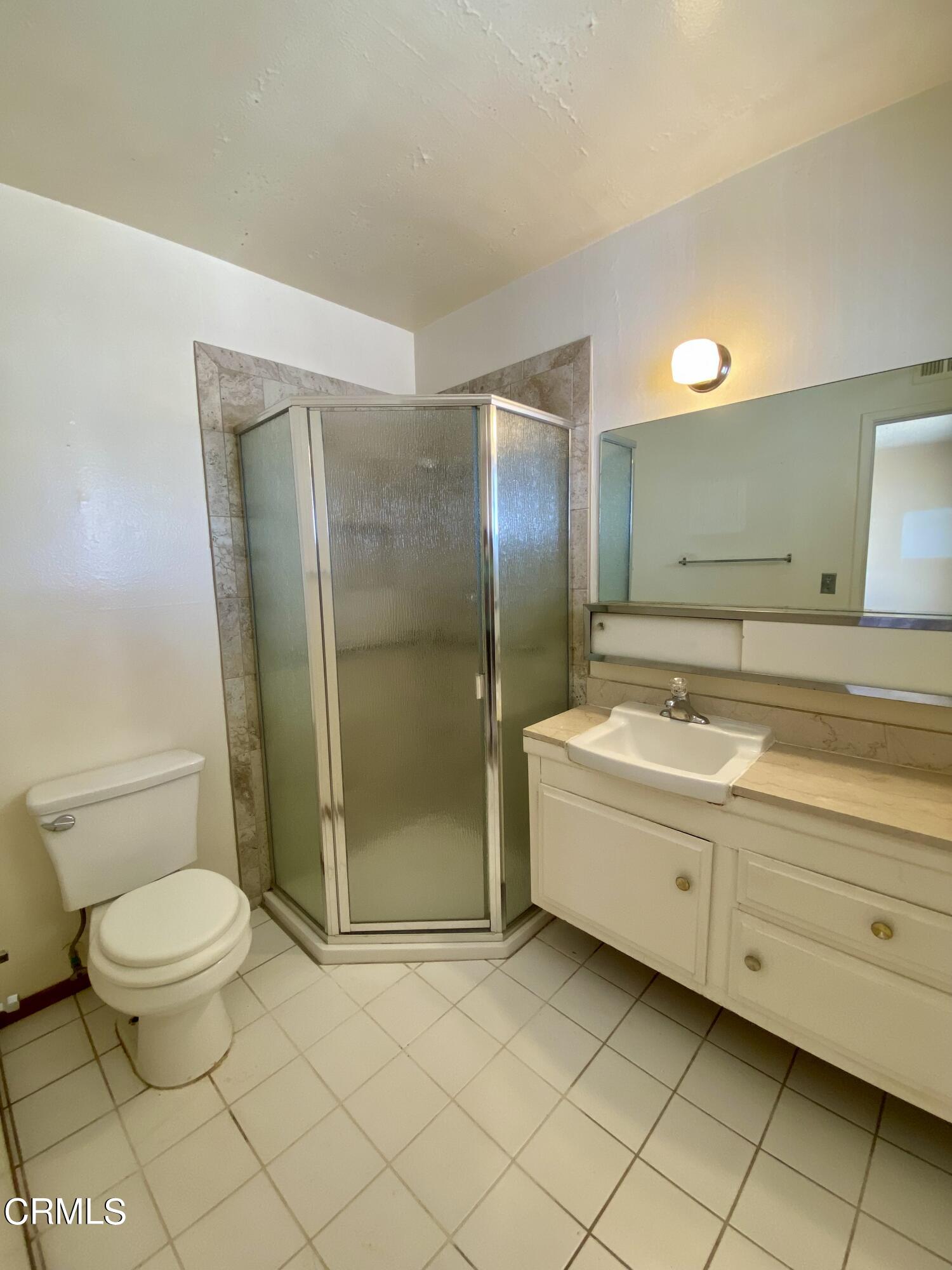 930 West Olive Street Oxnard, CA 93033 - Photo 20 of 22 a bathroom with a granite countertop toilet and a shower