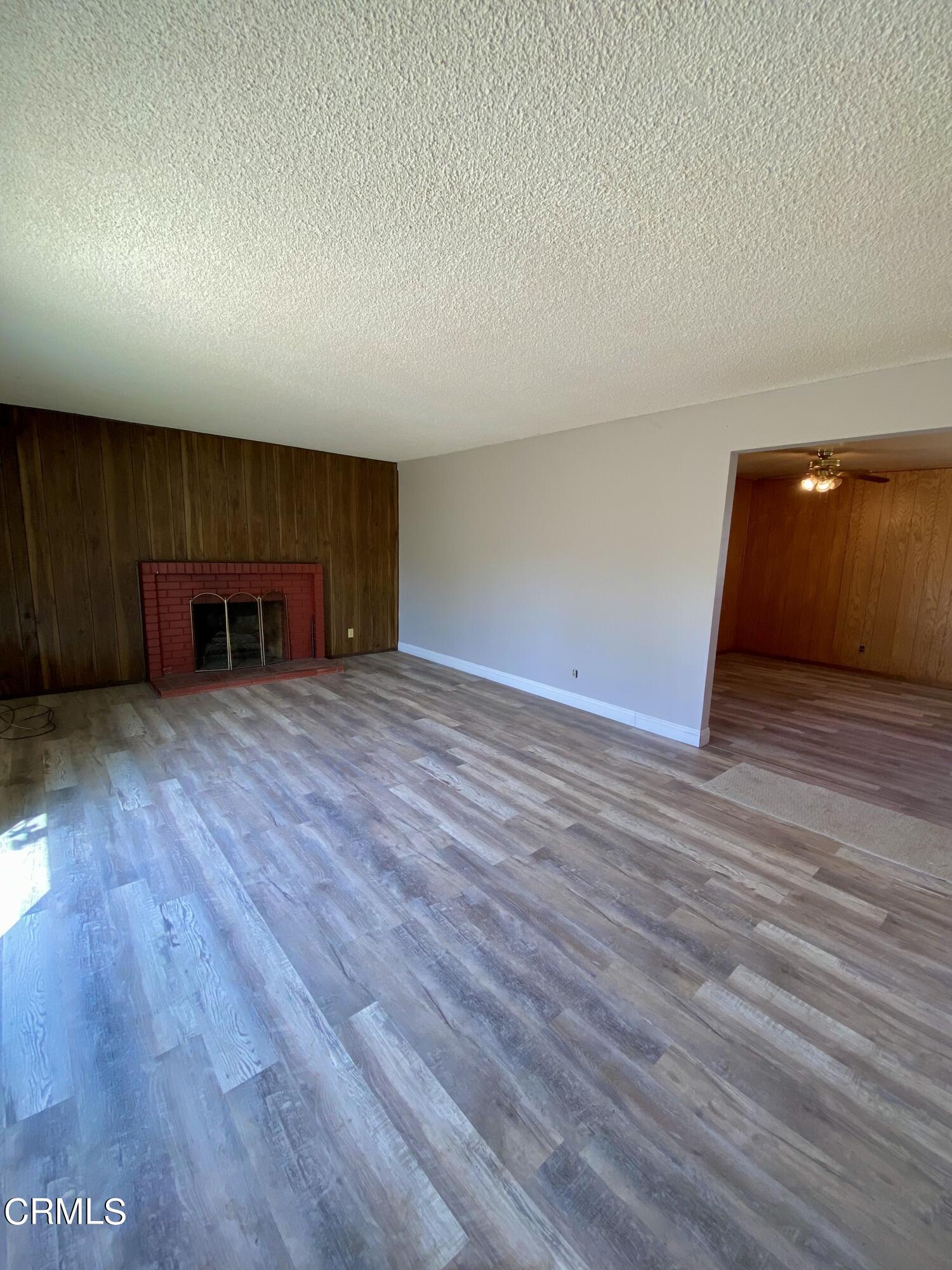 930 West Olive Street Oxnard, CA 93033 - Photo 3 of 22 a view of an empty room with wooden floor and a window