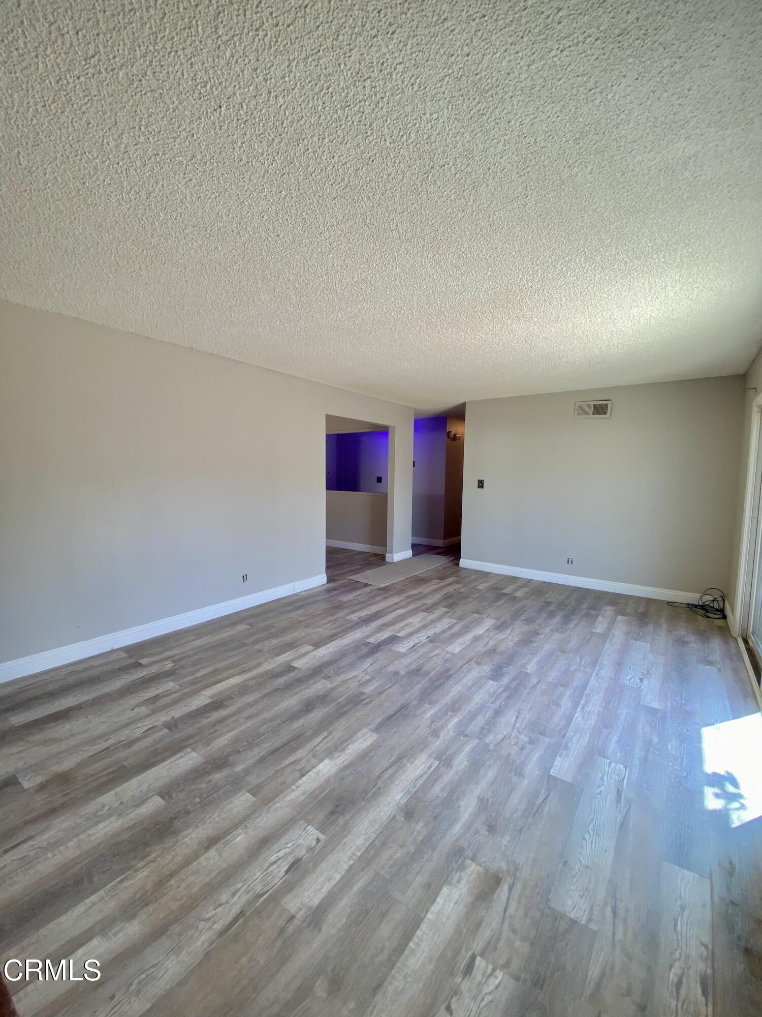930 West Olive Street Oxnard, CA 93033 - Photo 4 of 22 an empty room with wooden floor and windows