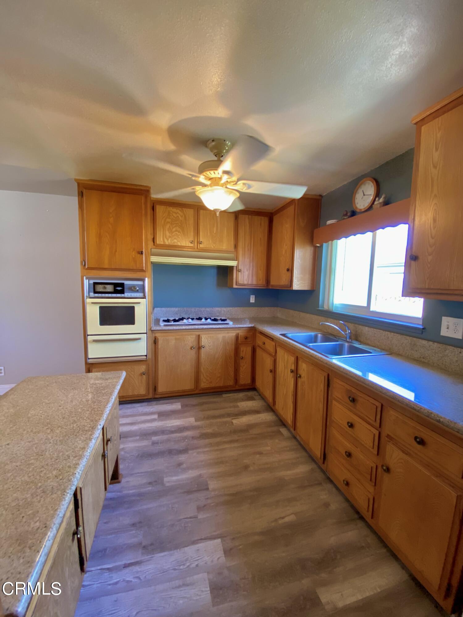930 West Olive Street Oxnard, CA 93033 - Photo 8 of 22 a large kitchen with wooden floors and stainless steel appliances