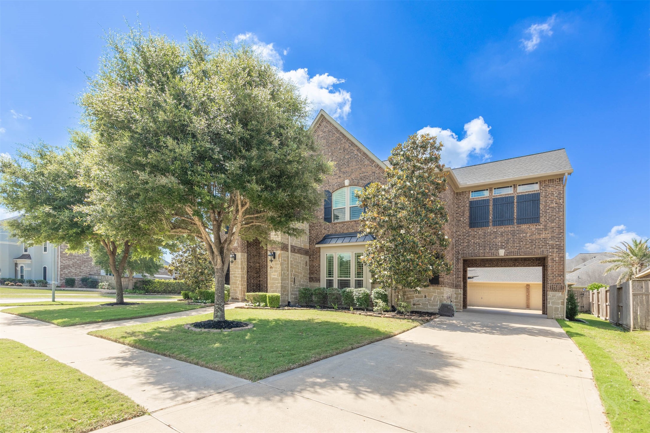 5803 Mustang Ridge Lane Fulshear, TX 77441 - Photo 45 of 48 Spacious porte cochere and extended driveway create a private courtyard-style entrance leading to the detached 3 car garage. The covered access adds convenience while enhancing the home’s impressive architectural presence.