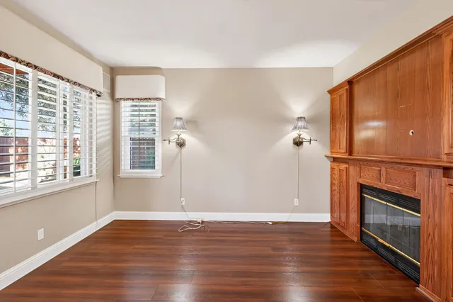 an empty room with wooden floor and fireplace