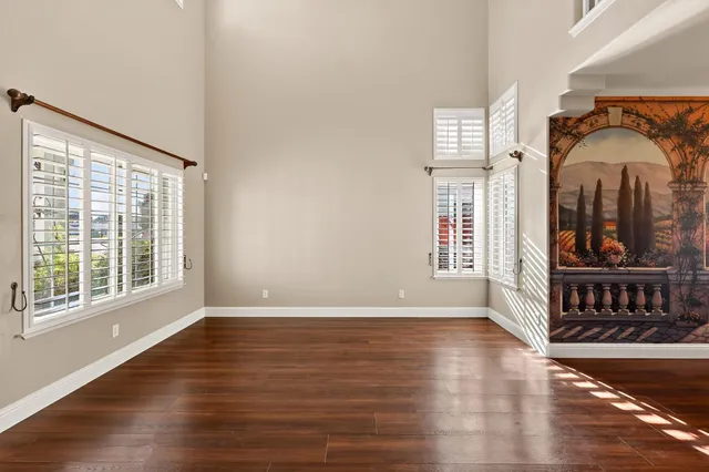 a view of a room with wooden floor and lots of windows