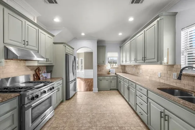 a kitchen with stainless steel appliances granite countertop a sink stove and refrigerator