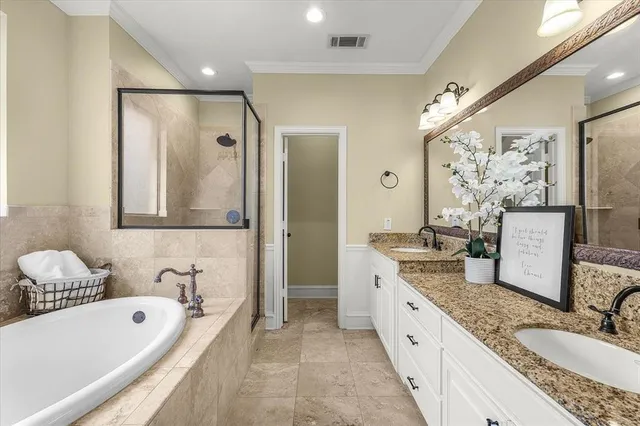 a bathroom with a granite countertop tub sink and mirror