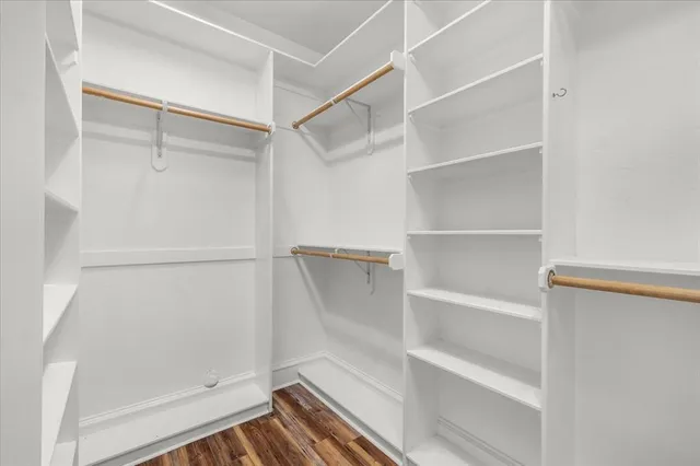 a view of walk in closet with empty racks