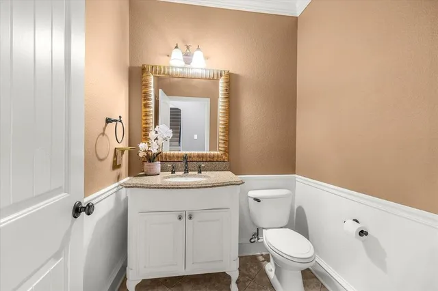 a bathroom with a granite countertop sink a toilet and a mirror