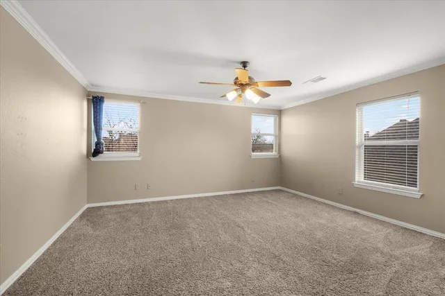 an empty room with windows and fan