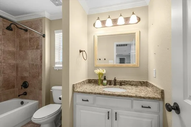 a bathroom with a granite countertop sink a toilet and shower