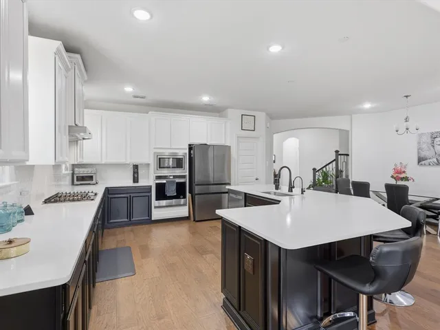 a kitchen with refrigerator cabinets dining table and chairs