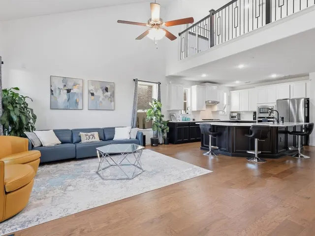 a living room with furniture kitchen view and a chandelier
