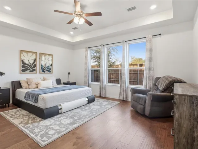 a spacious bedroom with a bed a couch and a large window