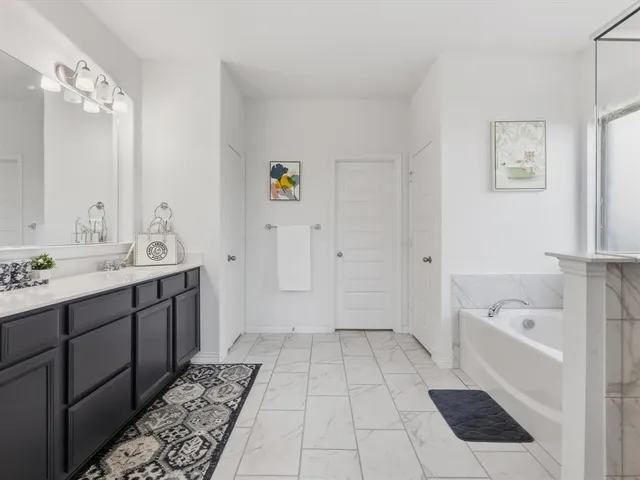 a bathroom with a tub sink and mirror