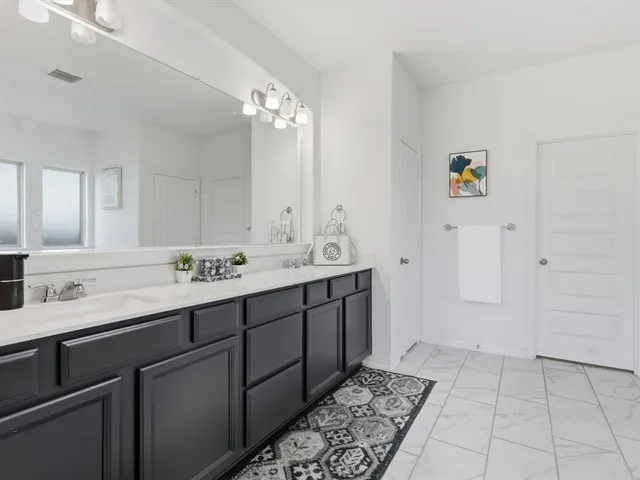 a bathroom with a double vanity sink and a mirror
