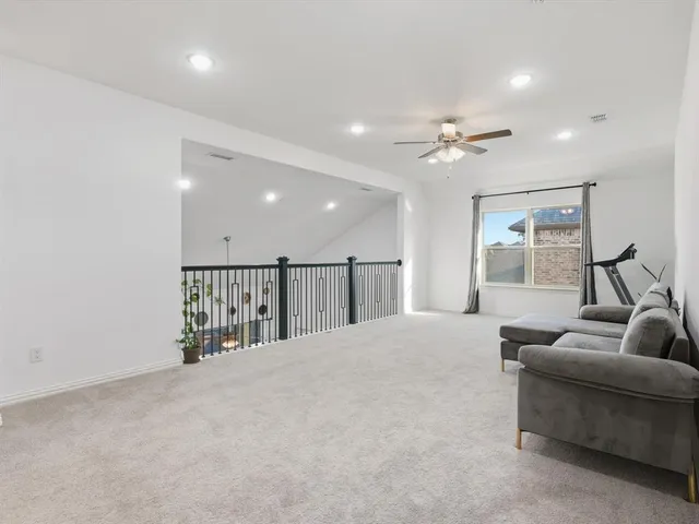 a living room with furniture and a ceiling fan