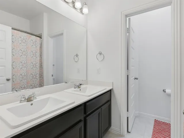 a bathroom with a double vanity sink and mirror
