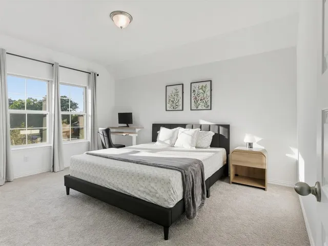 a spacious bedroom with a bed and glass window