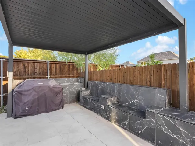 a view of outdoor sitting area with furniture and wooden fence