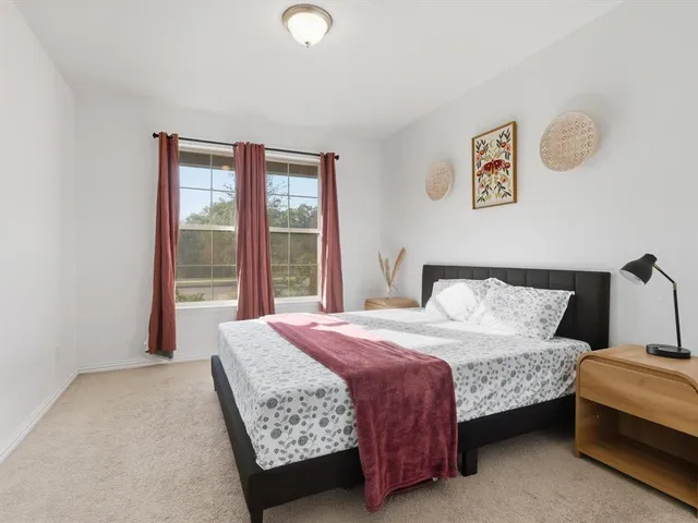 a bedroom with a bed and a large window