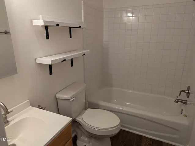 a white toilet sitting next to a bath tub