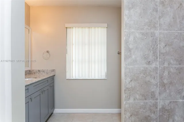 a bathroom with a granite countertop sink a mirror and a shower