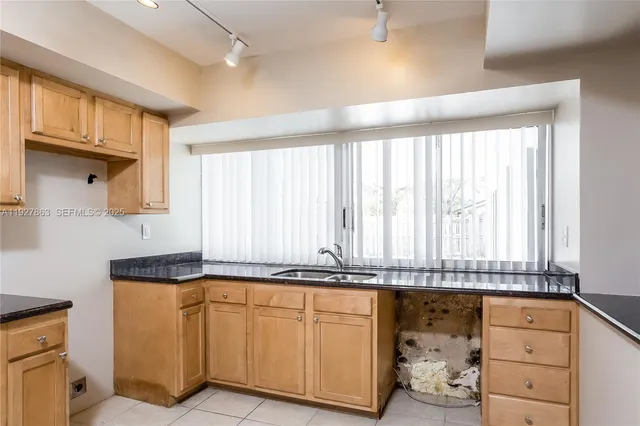 a kitchen with granite countertop white cabinets and white appliances