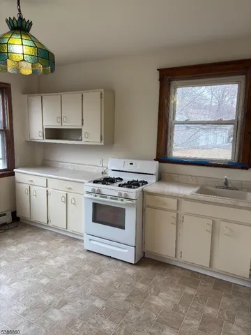 a kitchen with granite countertop white cabinets and white appliances