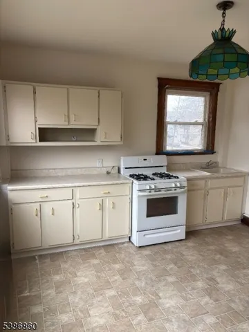 a kitchen with granite countertop white cabinets and white appliances