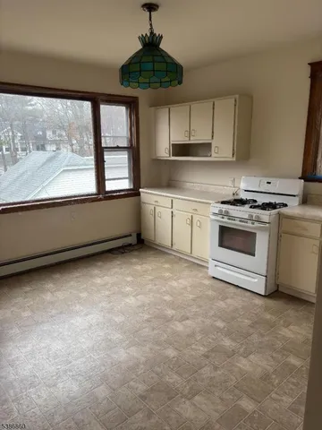a kitchen with a stove a sink and a granite counter top