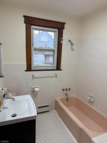 a bathroom with a tub sink and mirror
